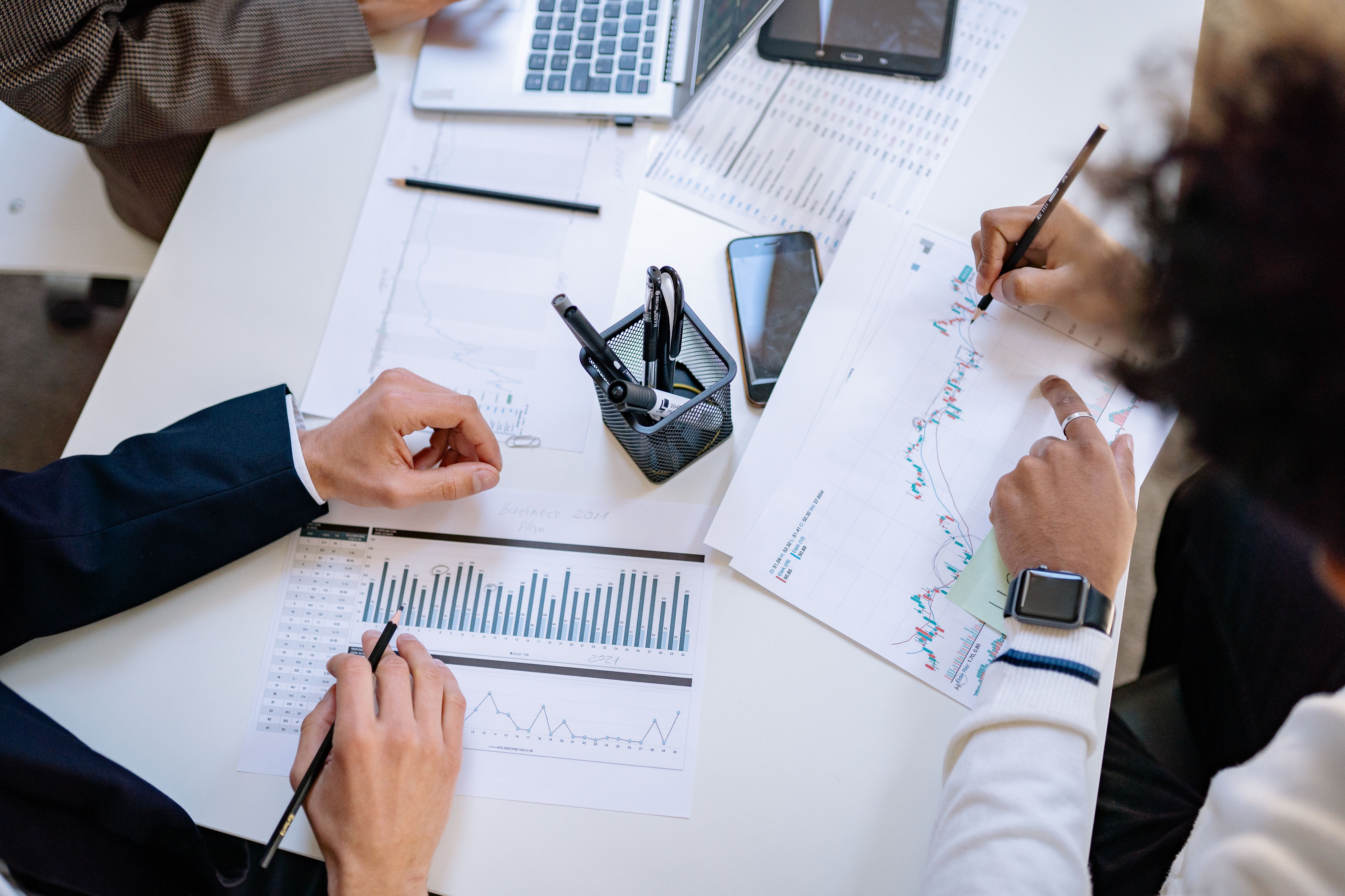 Groupe de professionnels analysant des graphiques et notes sur bureau, planifiant l’optimisation SEO avec Sedestral pour WordPress.