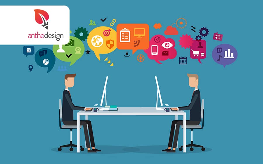 Deux professionnels assis face à face à des bureaux, chacun sur son ordinateur, entourés d’icônes colorées représentant le web et le marketing numérique.
